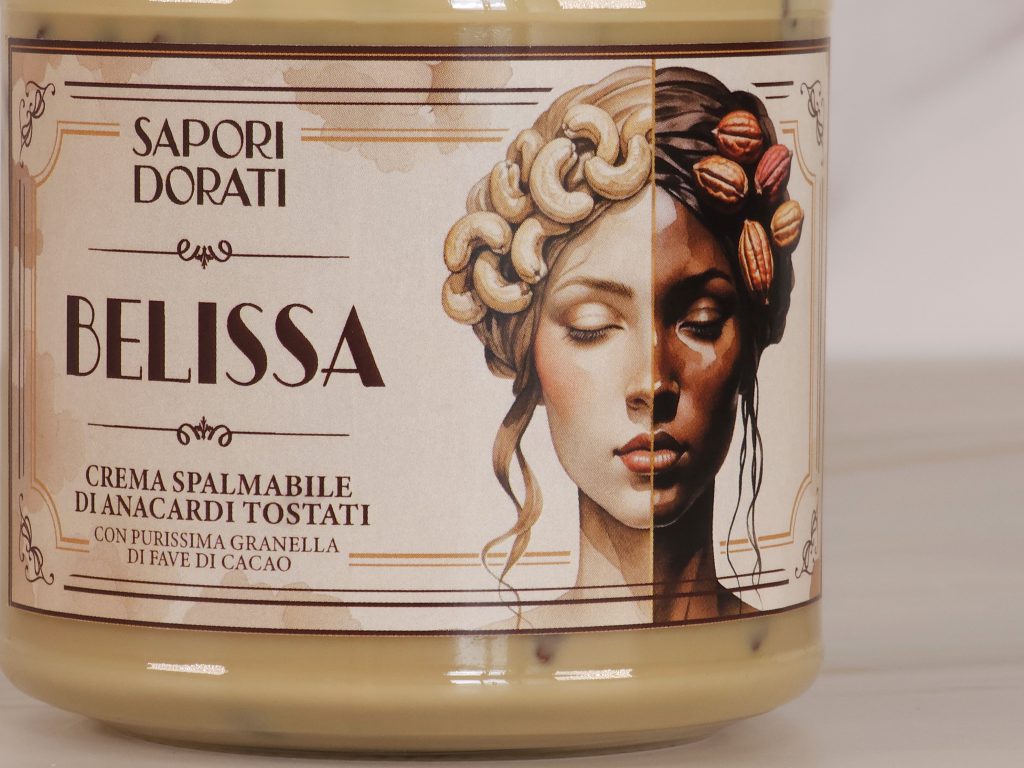 Barattolo con etichetta crema spalmabile Belissa. Mostra il contrasto tra il chiaro degli anacardi, e lo scuro delle fave di cacao. Così come il gusto, contrasto di sapori e consistenze.